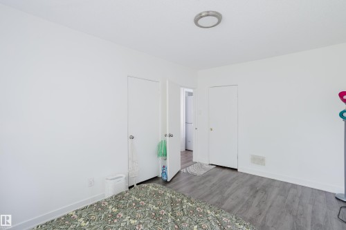White painted walls, wood-finish flooring, two doors, and a ceiling-mounted light fixture - 11134 11138 116 Street Nw, Edmonton, AB 