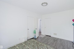 White painted walls, wood-finish flooring, two doors, and a ceiling-mounted light fixture - 