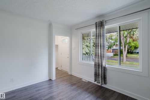 Wood-finish flooring, white trim, and a white ceiling with a textured finish - 11134 11138 116 Street Nw, Edmonton, AB 