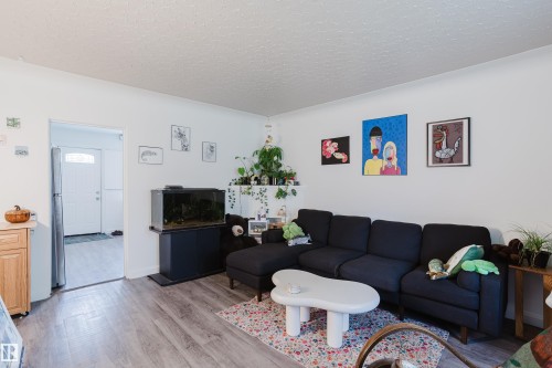 Wood-finish flooring throughout, bright white walls, and a recessed entryway - 11134 11138 116 Street Nw, Edmonton, AB 