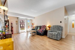 Light wood-finish flooring throughout, bright neutral wall paint, and large sliding glass doors leading to the exterior - 