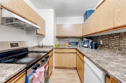 Kitchen featuring wood-finish cabinetry, patterned laminate countertops, a tile backsplash, stainless steel range, and a dishwasher - 