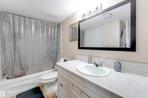 White vanity with chrome hardware, an integrated sink, and a white countertop - #101 49 Akins Dr, St. Albert, AB 