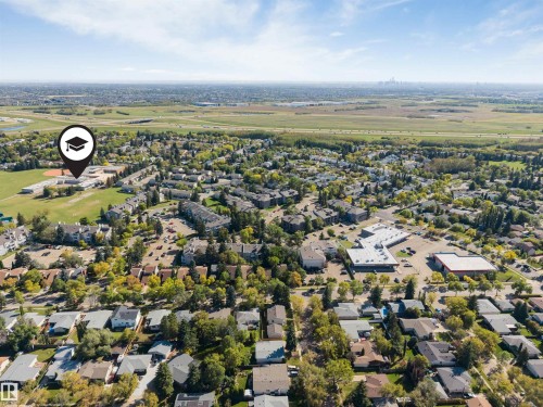 Expansive aerial encompassing a residential area, educational facility with athletic fields, and commercial buildings - #101 49 Akins Dr, St. Albert, AB 