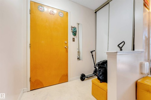 Entryway featuring a solid panel door, light-colored walls, and carpet flooring - #101 49 Akins Dr, St. Albert, AB 