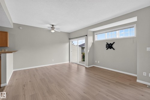 Wood-finish flooring, sliding glass door, transom window, ceiling fan, and breakfast bar - #156 460 Cranberry Wy, Sherwood Park, AB 
