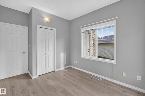 Wood-finish flooring, white trim, and a bi-fold closet door - #156 460 Cranberry Wy, Sherwood Park, AB 