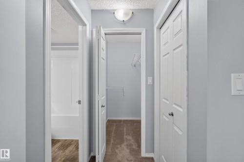 Hallway with paneled doors, light gray wall paint, and overhead lighting - #156 460 Cranberry Wy, Sherwood Park, AB 