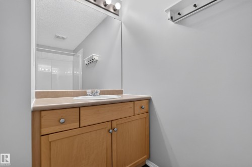 Light wood-finish vanity with an integrated sink and laminate countertop - #156 460 Cranberry Wy, Sherwood Park, AB 