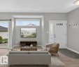 Light wood-finish flooring, sliding glass door, transom window, recessed ceiling lighting, and a paneled entry door with sidelight - #156 460 Cranberry Wy, Sherwood Park, AB 