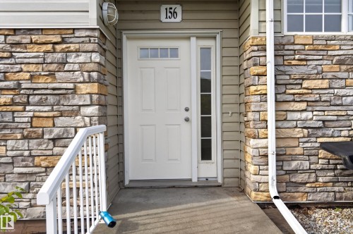 Entryway featuring a panel door with transom, sidelight, and an overhead light fixture - #156 460 Cranberry Wy, Sherwood Park, AB 