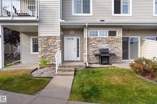 Entryway featuring stone-look accent siding and a white entry door - #156 460 Cranberry Wy, Sherwood Park, AB 