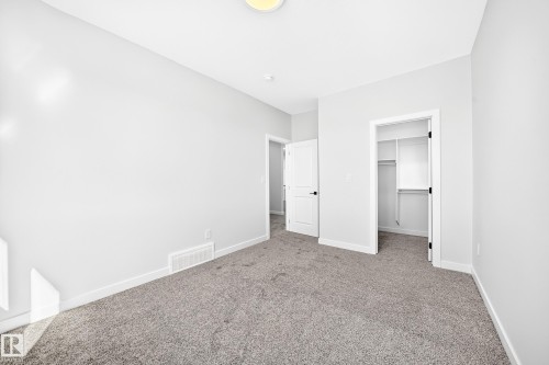 Plush gray carpet, white painted walls, white trim, and a built-in closet with shelving - 19 Tuplet Bay, Spruce Grove, AB 