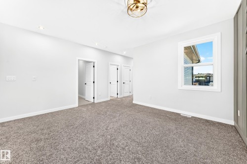 Recessed ceiling lighting, a modern semi-flush mount fixture, and soft grey carpeting - 19 Tuplet Bay, Spruce Grove, AB 