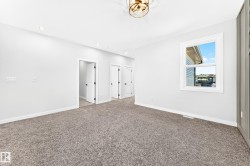 Recessed ceiling lighting, a modern semi-flush mount fixture, and soft grey carpeting - 