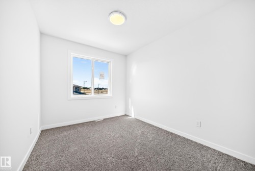 Window with white trim, wall-to-wall carpeting, white walls, and a ceiling-mounted light fixture - 19 Tuplet Bay, Spruce Grove, AB 
