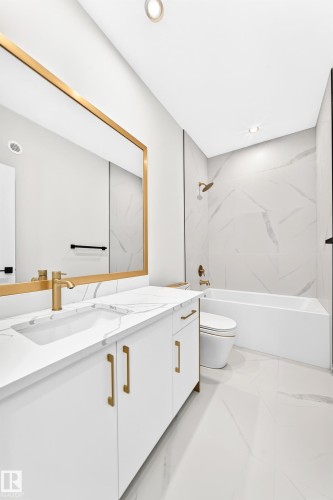 White vanity with gold-finish hardware and integrated sink - 19 Tuplet Bay, Spruce Grove, AB 
