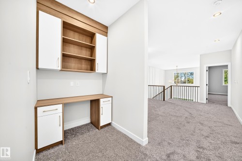 Built-in desk with wood-finish countertop and white cabinetry - 19 Tuplet Bay, Spruce Grove, AB 