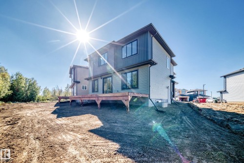 Rear exterior with light-colored siding, dark trim, and a constructed wooden deck - 19 Tuplet Bay, Spruce Grove, AB 