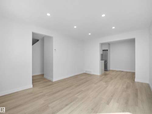 Recessed lighting, light wood-finish flooring, white walls, stainless steel refrigerator, and a built-in kitchen peninsula - 12C Twin Terrace Nw, Edmonton, AB 