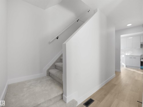 Carpeted staircase with a white handrail, wood-finish flooring, and recessed lighting - 12C Twin Terrace Nw, Edmonton, AB 