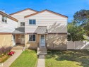Vinyl siding exterior with a shingled roof, concrete pathway, and front lawn - 12C Twin Terrace Nw, Edmonton, AB 