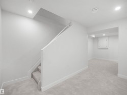 Carpeted staircase with recessed lighting, leading to a spacious carpeted area - 