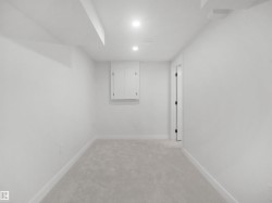 Recessed lighting, wall-mounted cabinetry, soft gray carpeting, and white trim - 