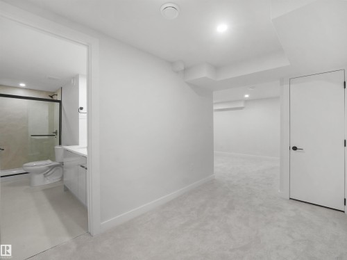 Plush carpeting throughout, recessed lighting, and a white interior door with matte black hardware - 12C Twin Terrace Nw, Edmonton, AB 