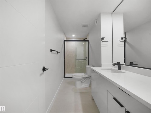 White floating vanity with integrated sink, matte black faucet, frameless mirror, and glass-enclosed shower with black trim - 12C Twin Terrace Nw, Edmonton, AB 