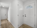 Entryway featuring light wood-finish flooring, white walls, and a front door with an arched transom window - 12C Twin Terrace Nw, Edmonton, AB 