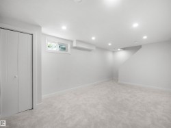 Recessed ceiling lighting, light gray wall paint, light gray carpeting, bi-fold closet doors, and a window - 