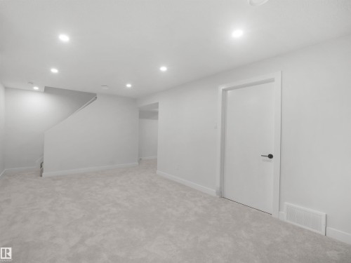 Recessed lighting, light gray carpeting, white walls, white trim, and a white interior door with matte black hardware - 12C Twin Terrace Nw, Edmonton, AB 