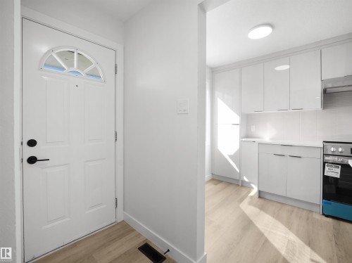 Arched transom window above a panel door with matte black hardware - 12C Twin Terrace Nw, Edmonton, AB 