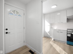 Arched transom window above a panel door with matte black hardware - 