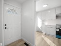 Arched transom window above a panel door with matte black hardware - 12C Twin Terrace Nw, Edmonton, AB 