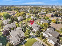 Townhome community featuring mature landscaping, paved pathways, and multiple buildings with grey shingle roofs - 