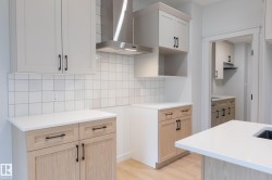 Two-tone cabinetry, stainless steel range hood, white square tile backsplash, white countertops, and wood-finish flooring - 