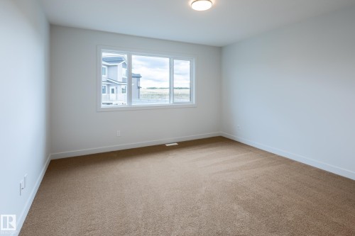 Recessed lighting, neutral paint, carpeted flooring, and a large window - 4005 36 Street, Beaumont, AB 