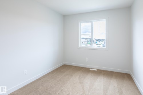 Neutral wall color, wall-to-wall carpeting, and a window with white trim - 4005 36 Street, Beaumont, AB 
