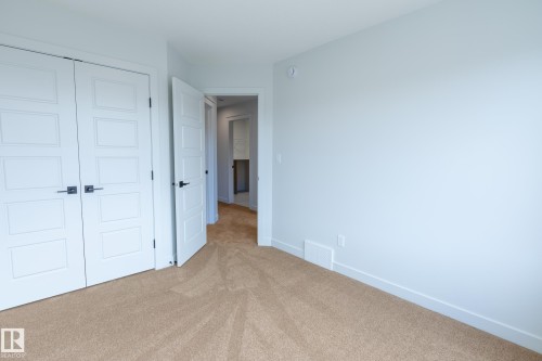Wall-to-wall carpeting, modern paneled doors, and contemporary black hardware - 4005 36 Street, Beaumont, AB 