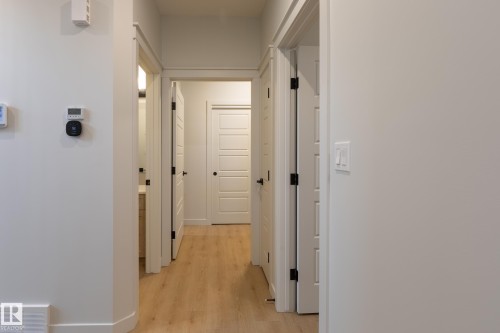 Light wood-finish flooring extending through the hallway - 4005 36 Street, Beaumont, AB 