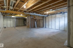 Unfinished basement with concrete flooring, exposed wood ceiling joists, and insulated perimeter walls - 