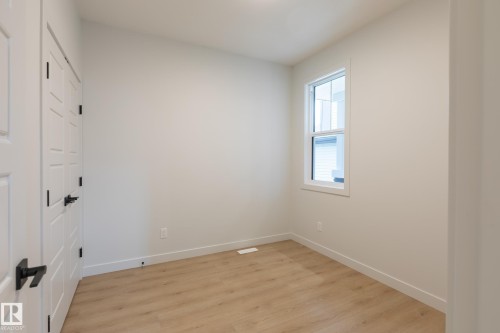 Light wood-finish flooring, white walls, and a double-hung window - 4005 36 Street, Beaumont, AB 