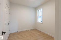 Light wood-finish flooring, white walls, and a double-hung window - 