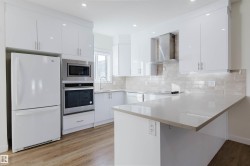 Contemporary kitchen featuring white cabinetry, light-toned countertops, a full suite of appliances, recessed lighting, and wood-finish flooring - 