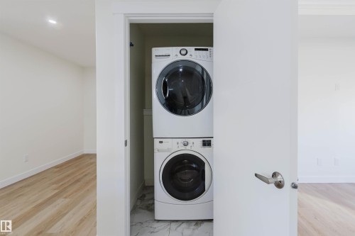 Dedicated laundry closet with stacked washer and dryer, set on a tiled floor - 6047 180 Avenue Nw, Edmonton, AB 