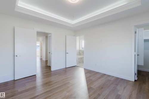 Tray ceiling with recessed lighting, wood-finish flooring, and white interior doors - 6047 180 Avenue Nw, Edmonton, AB 