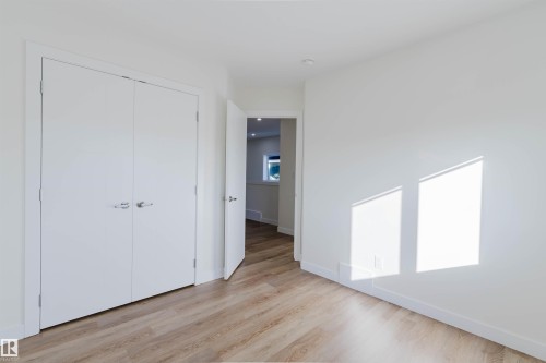 White walls, wood-finish flooring, recessed ceiling lighting, and white trim - 6047 180 Avenue Nw, Edmonton, AB 
