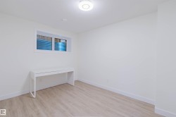 Recessed window with blue-tinted window well, light wood-finish flooring, and white walls - 